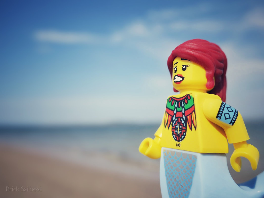 A minifigure mermaid practices her best toy photography smile
