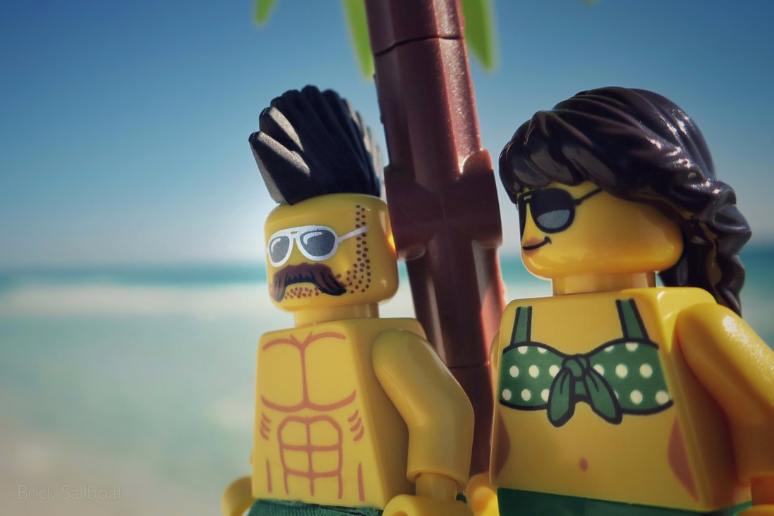A LEGO stud and his girl dressed in green chill under the palm tree beachside