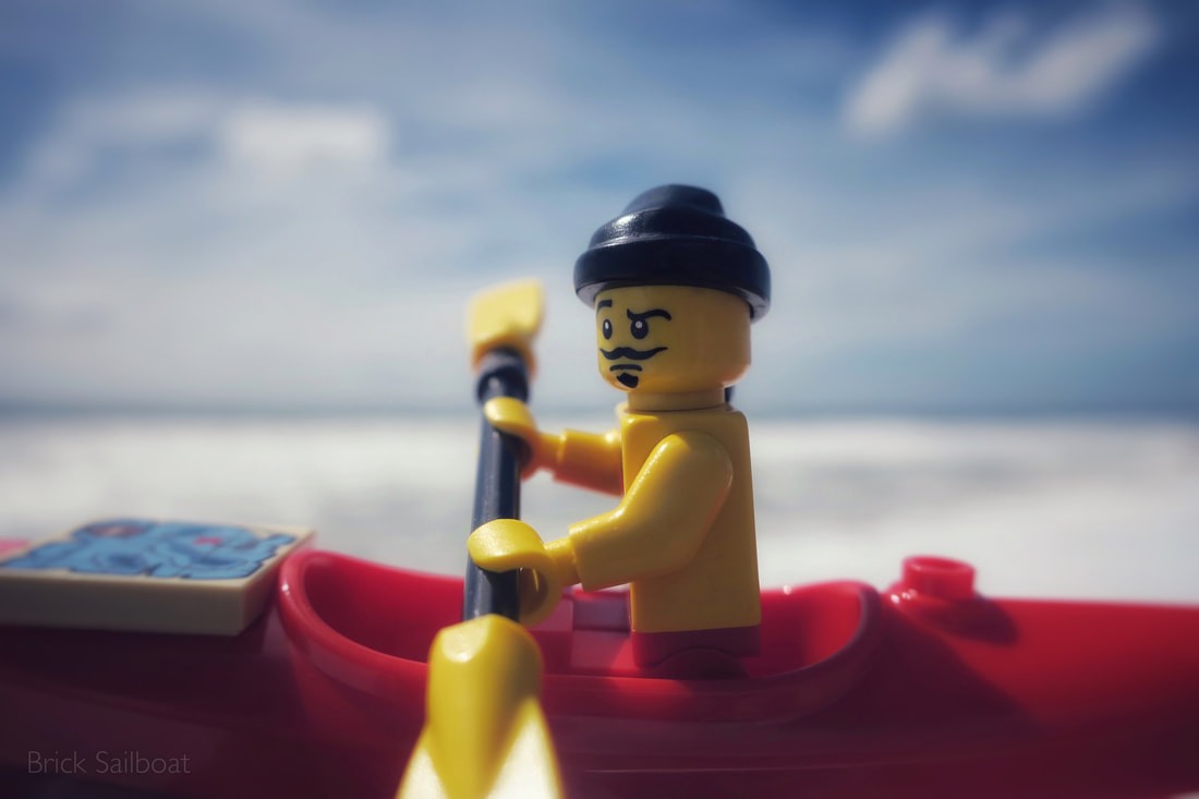 LEGO pirate kayaking in the surf with a treasure map.